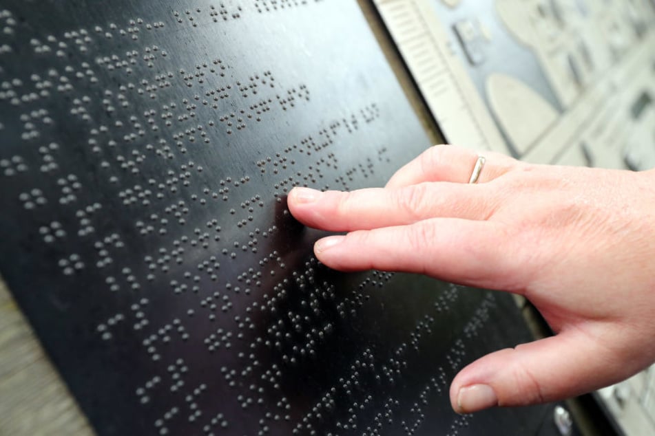 Besuch im Leipziger Duft- und Tast-Garten: Mit ihren Fingerkuppen kann Christiane die Braille-Schrift entziffern.
