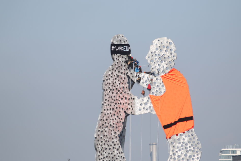 Die Aktivisten zogen dem "Molecule Man" eine Warnweste an.