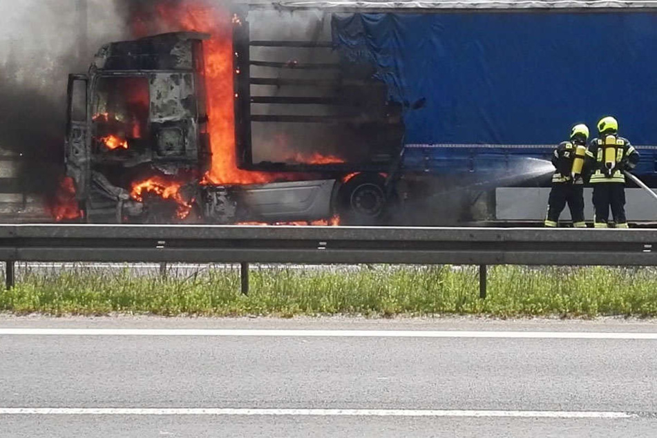 Kameraden der Feuerwehr löschen den Brand an dem Sattelzug.