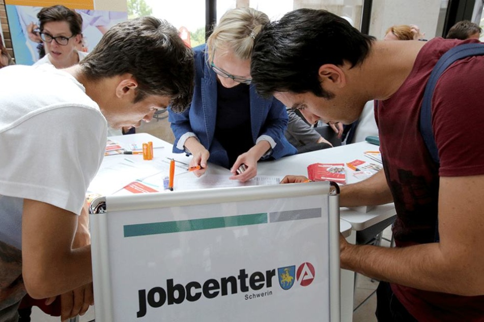 Junge Geflüchtete informieren sich auf eine Ausbildungsmesse.