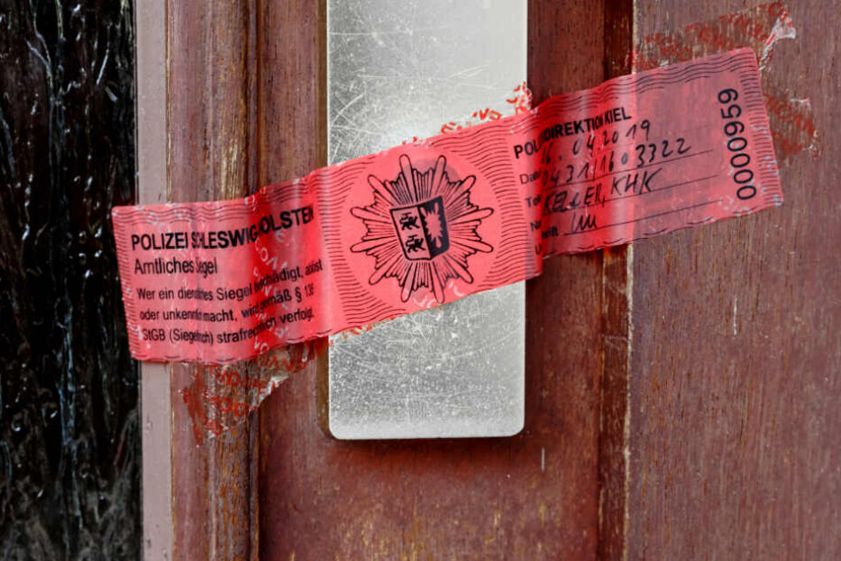 Ein Polizeisigel verschließt die Tür zur Wohnung der getöten Frau.