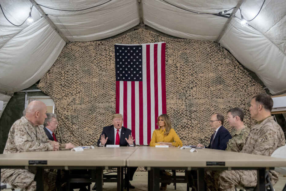 Donald Trump (Mitte l), Präsident der USA, First Lady Melania Trump und hochrangige Militärs bei einem Treffen auf dem Luftwaffenstützpunkt Al Asad. (Archivbild)