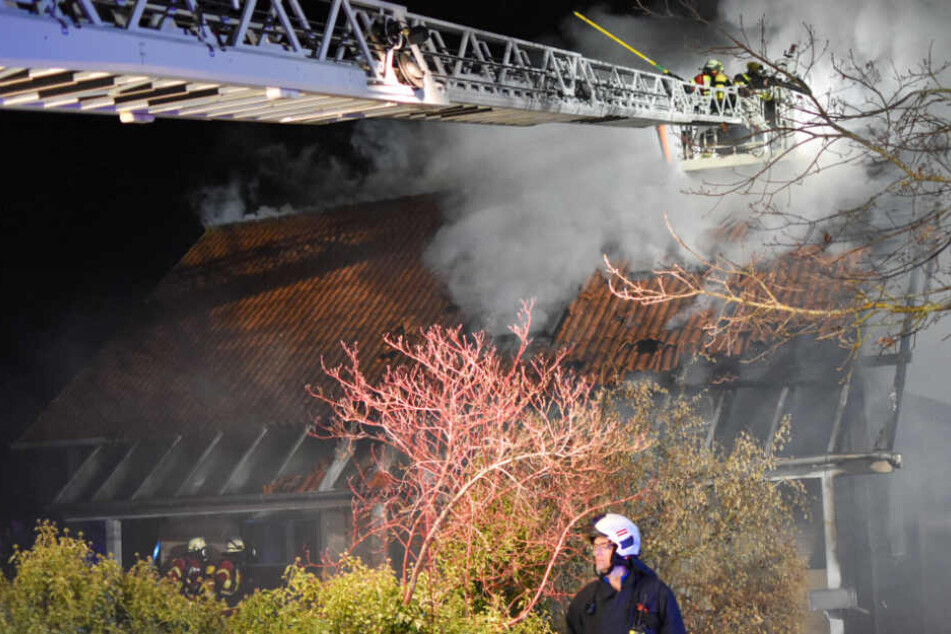 Die Feuerwehr kämpft gegen Rauch und Flammen an.