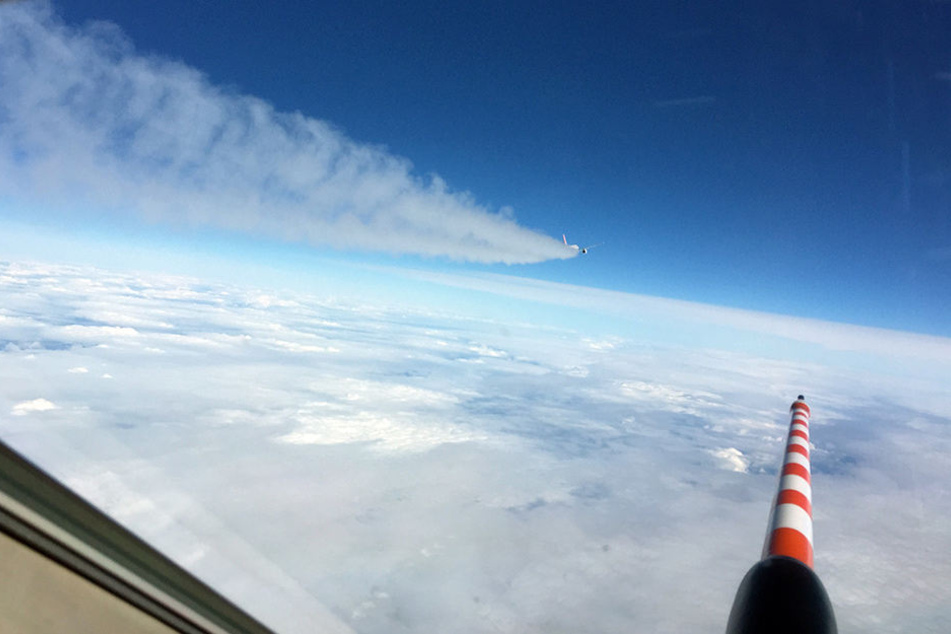 Voraus fliegt der DLR-Flieger, die NASA-Maschine fliegt durch den Kondensstreifen.