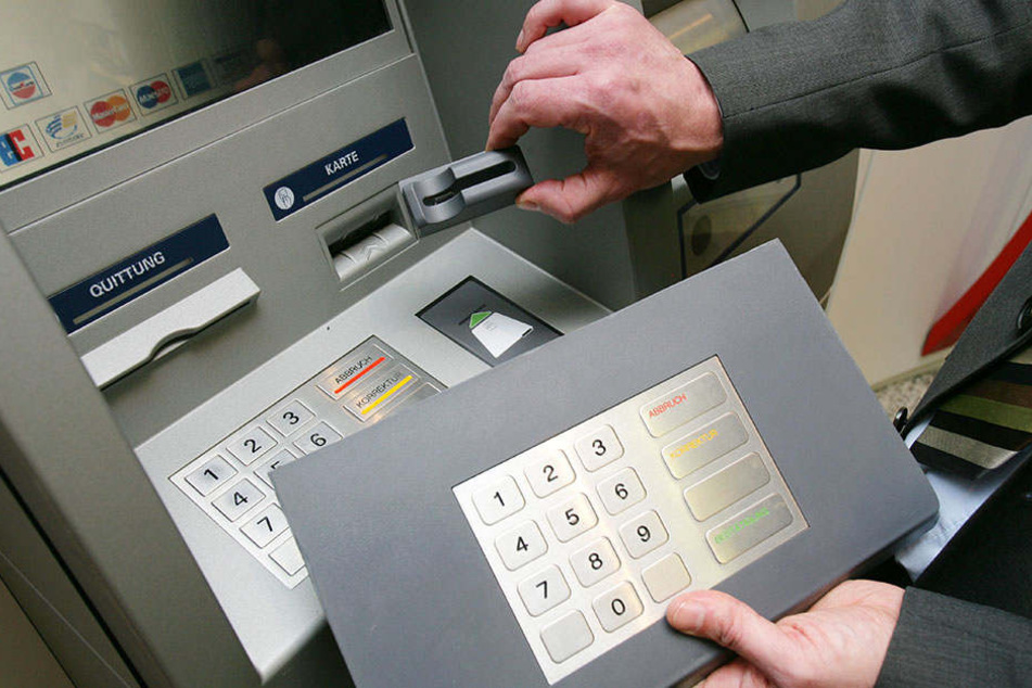 Ein Bank-Mitarbeiter zeigt eine der "Skimming"-Techniken. (Symbolbild)