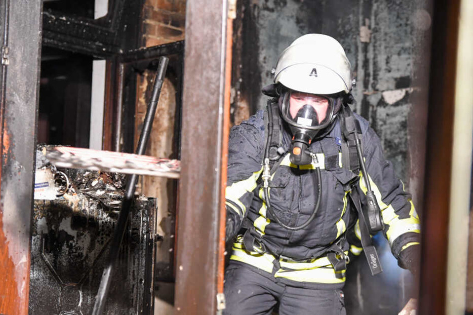 Ein Feuerwehrmann steht in dem ausgebrannten Zimmer.