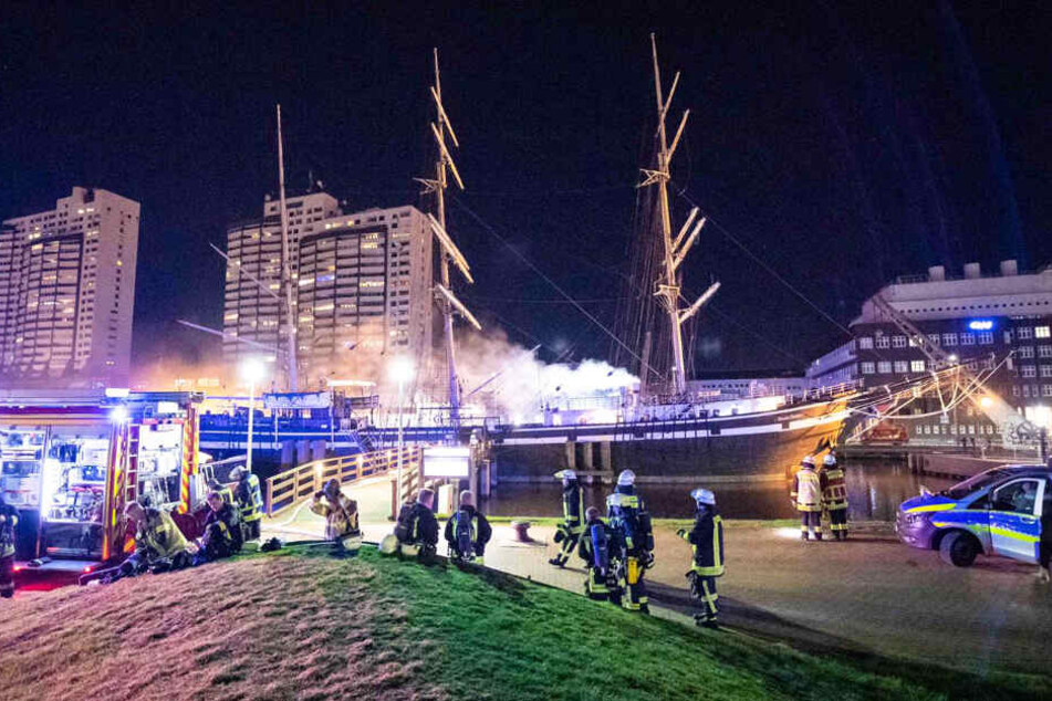 Rauch steigt aus dem Schiff "Seute Deern" auf. Feuerwehrleute bekämpfen den Brand.