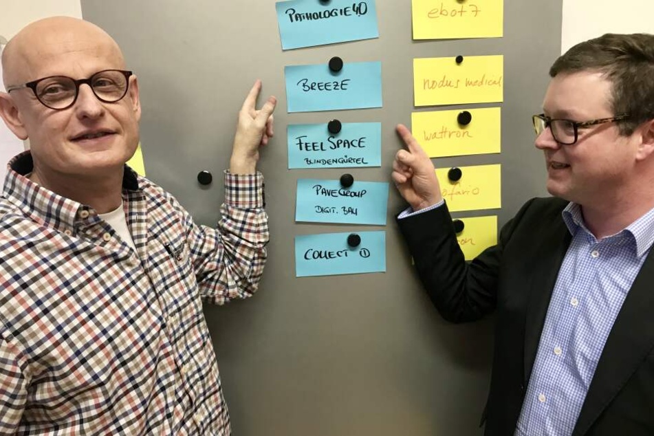 Die Jury-Mitglieder Dr. Marc Derungs (SAP, li.) und Dr. Claus von Campenhausen (Crédit Agricole CIB) vor dem Finalisten-Board.