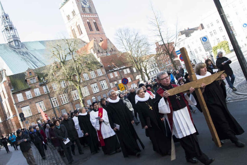 Teilnehmer tragen ein Holzkreuz bei der Begehung des ökumenischen Kreuzwegs, der als der älteste in Deutschland gilt.