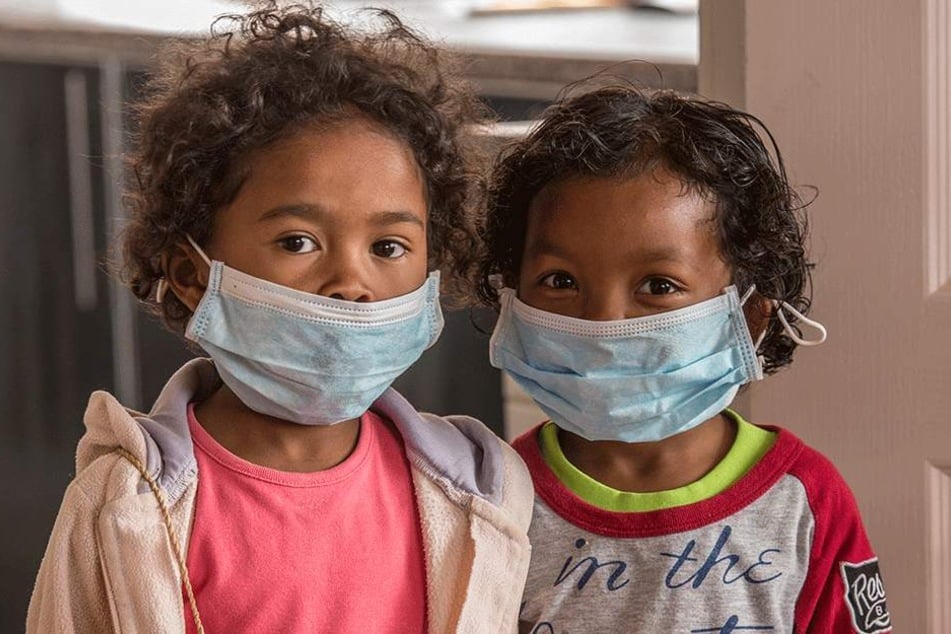 Kinder werden mit Mundschutz vor der tödlichen Pest geschützt.