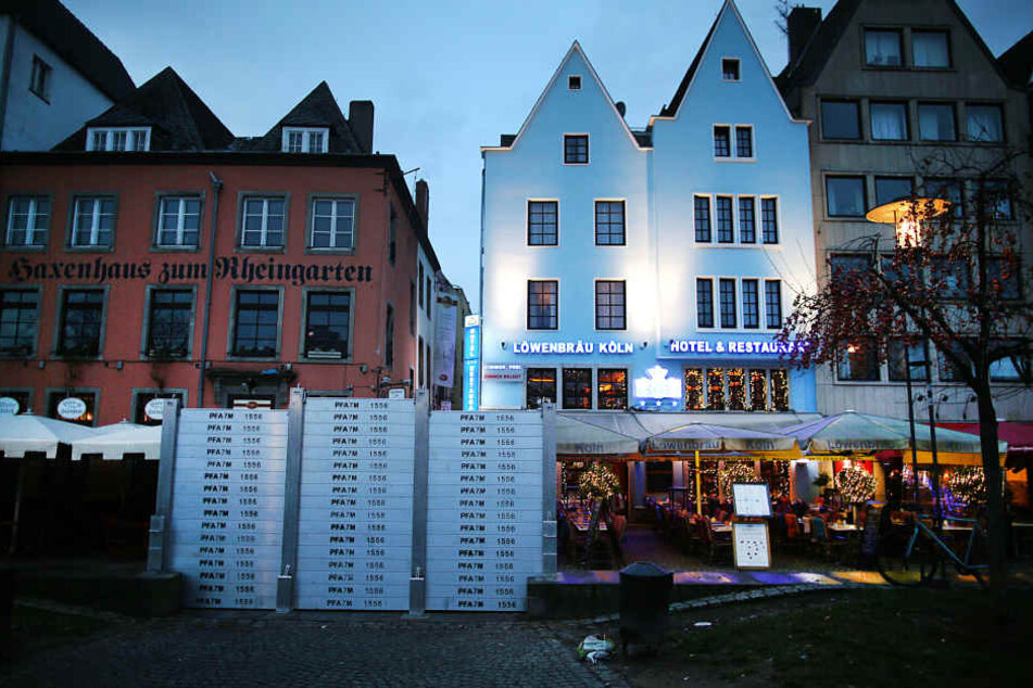 Hochwasserschutzwände stehen in Köln der Altstadt vor einem Lokal.