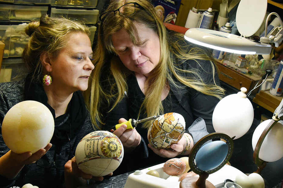 Die Hobby-Ostereiermalerin Susanne Liebscher (l.) arbeitet mit Kerstin Dischereit in deren kleinen Ostereier-Werkstatt an der Gestaltung von verschiedenen Nandu- und Straußeneiern.