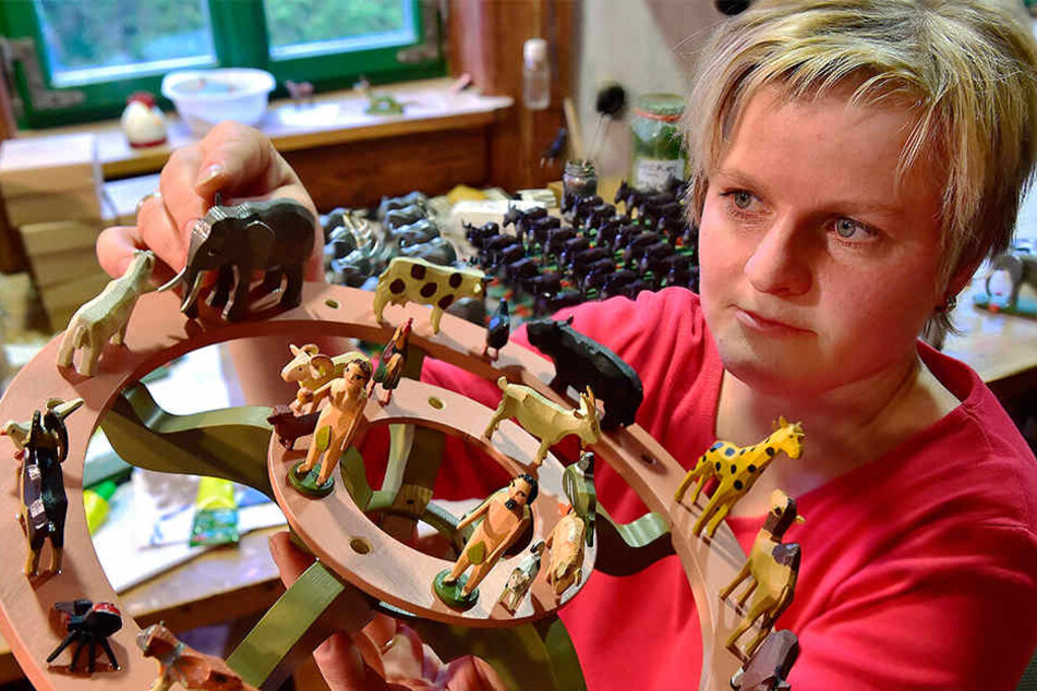 Spielzeugmacherin Tabea Drechsel ordnet in der Seiffener Werkstatt Werner Figuren auf einer Leuchter-Etage an