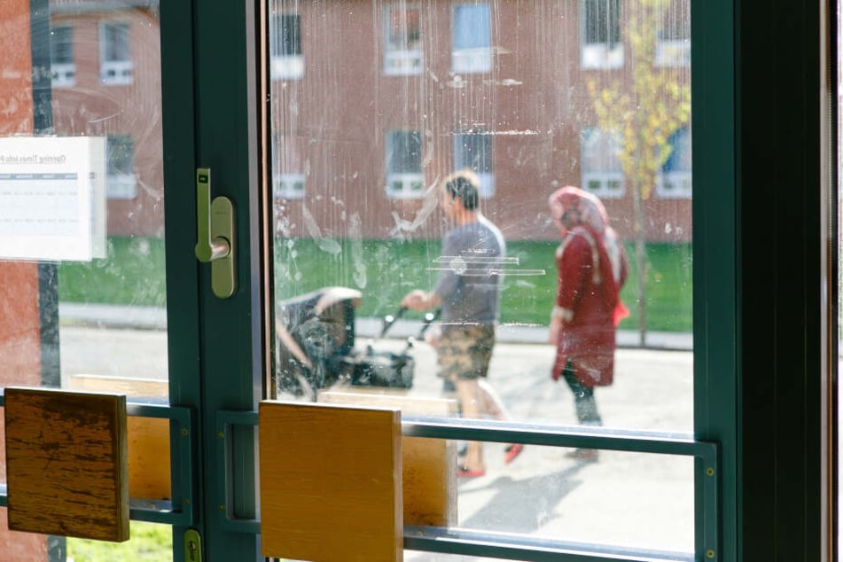 Eltern schieben beim Spaziergang einen Kinderwagen in einer Flüchtlingsunterkunft im schleswig-holsteinischen Boostedt.