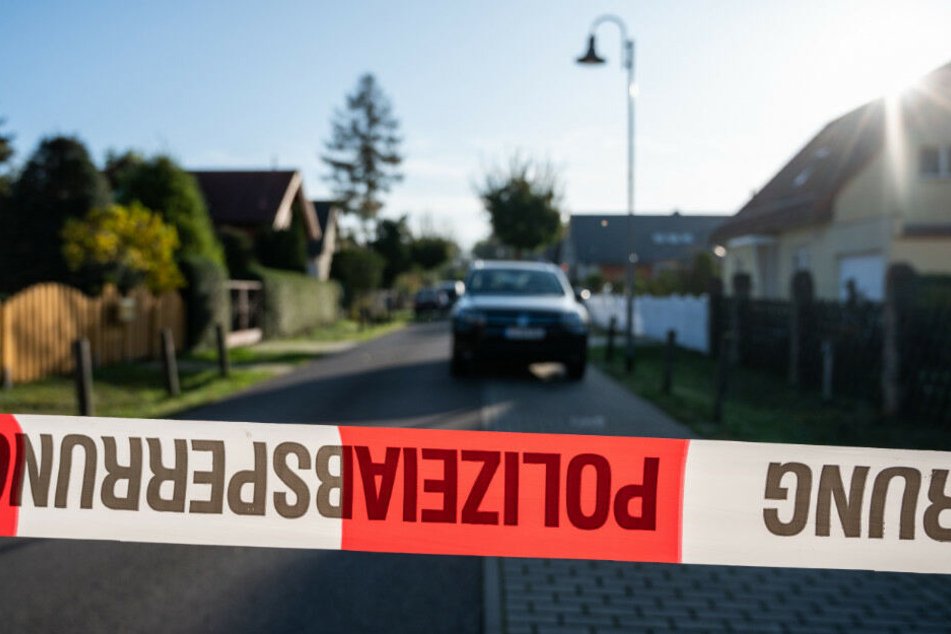Die Polizei sichert die Straße in Teltow mit einem Absperrband ab.
