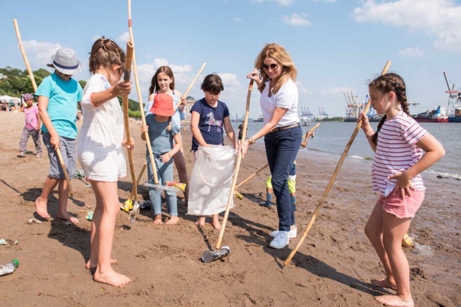 Zusammen mit Kindern sammelt Frauke Ludowig Müll am Elbstrand.