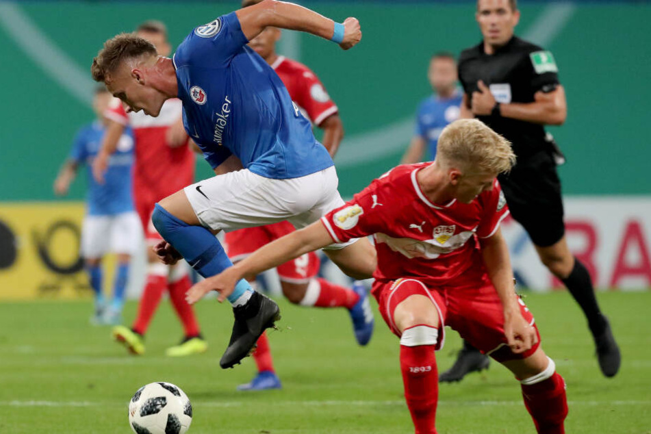 1. Runde des DFB-Pokals 2018/19: Der Rostocker Mirnes Pepic (l), Schütze des 2:0, setzt sich gegen den Stuttgarter Timo Baumgartl durch.