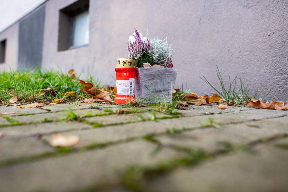 Eine Kerze und Blumen wurden vor dem Mehrfamilienhaus abgelegt.
