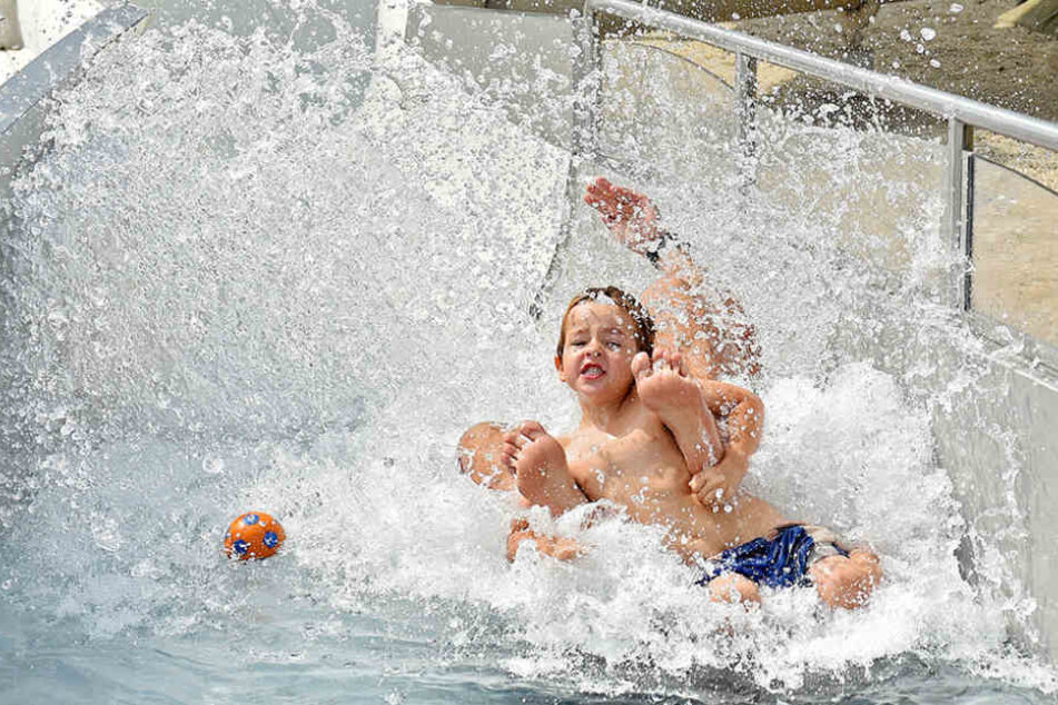 So lässt sich der Hitze-Sommer 2018 ertragen: Kinder rutschen im Freibad Cossebaude von der längsten Freibad-Rutsche der Stadt.