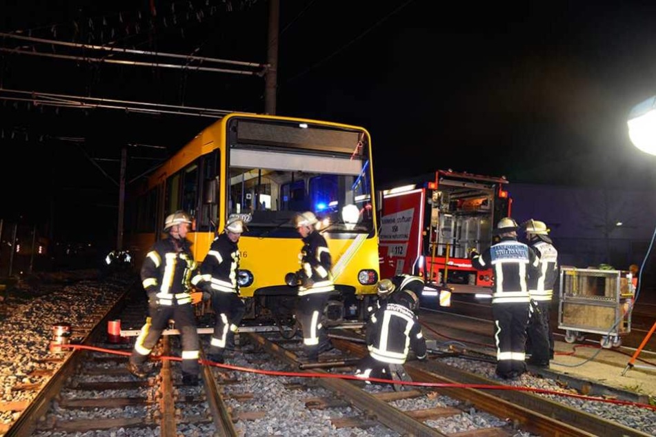 Rettungskräfte stehen an der entgleisten Bahn.