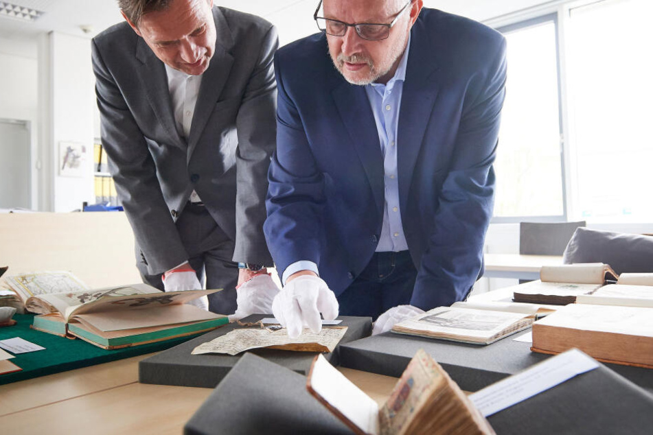 Ulrich Meyer-Doerpinghaus (l), Direktor der Universitäts- und Landesbibliothek Bonn, und Dezernent Michael Herkenhoff, schauen auf Bücher aus dem Vorkriegsbestand.