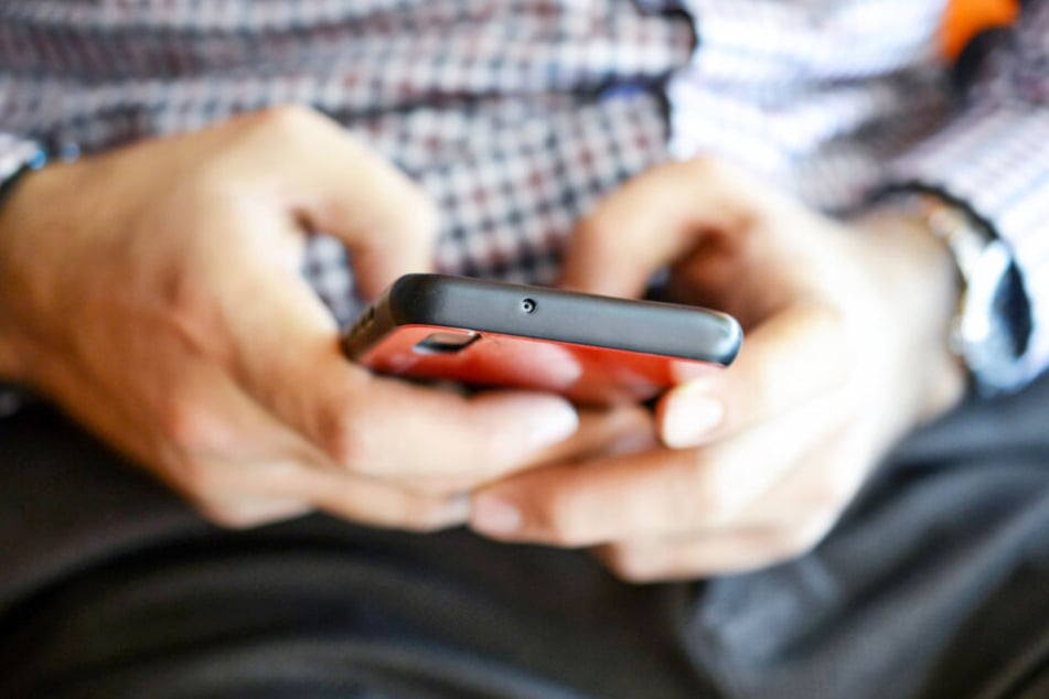 Ein Mann schreibt eine Nachricht auf seinem Smartphone (Symbolbild).