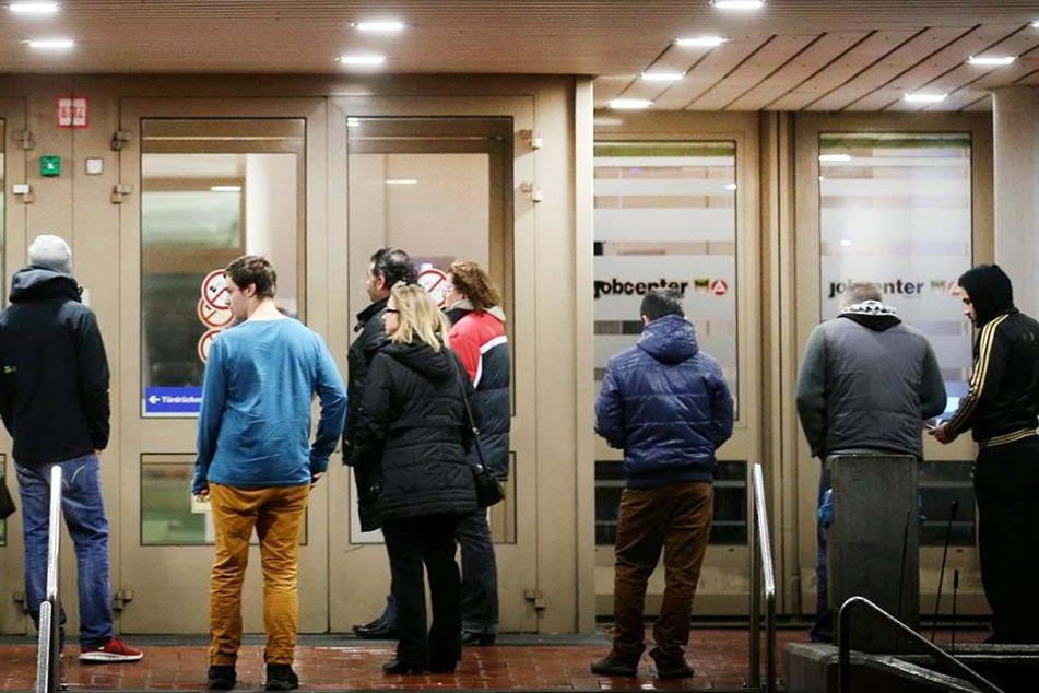 Arbeitssuchende stehen in Duisburg vor der Bundesagentur für Arbeit.