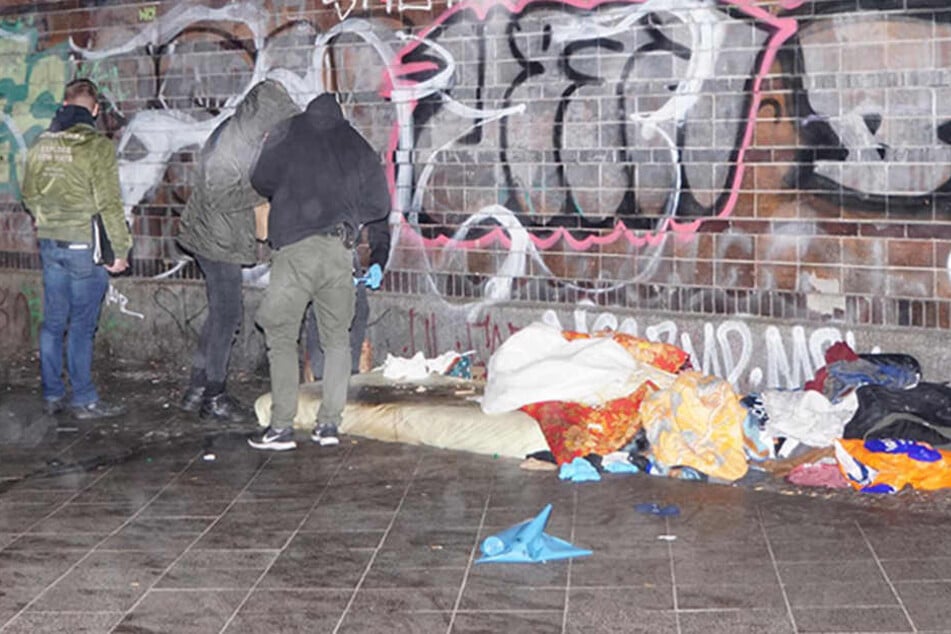 Beamte untersuchen den Schlafplatz des verstorbenen Mannes.