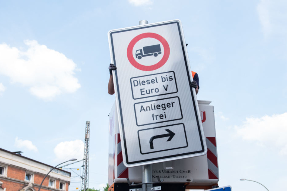 Ein Fahrverbotsschild für Lastwagen wird an der Max-Brauer-Allee aufgehängt.