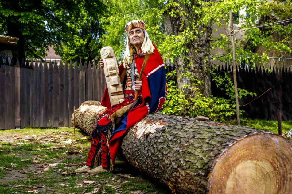 Der Indianer Edward Earl Bryant alias Slow Raven schnitzt einen Totempfahl aus einem Kieferstamm.
