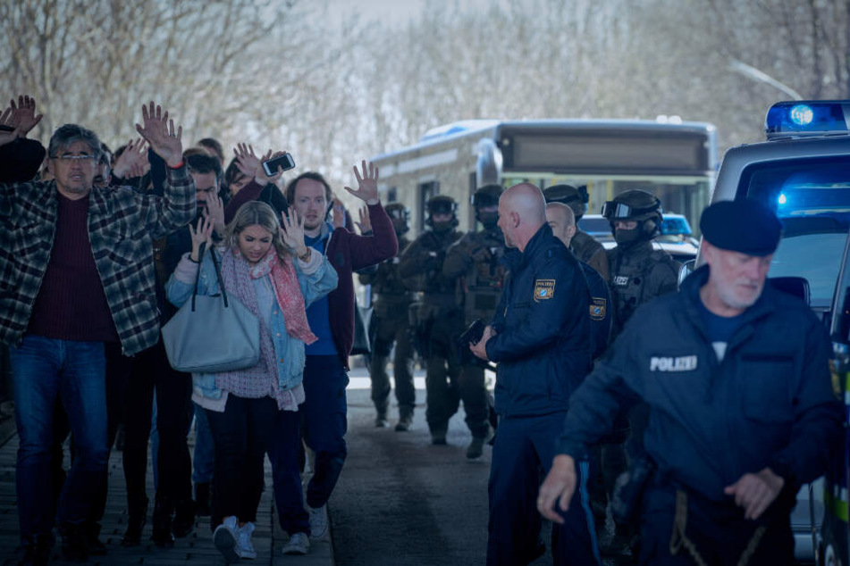 Die Polizei versucht nach der Tötung eines Fahrkartenkontrolleurs die Lage am Bus zu ordnen und bringt die Fahrgäste in Sicherheit.