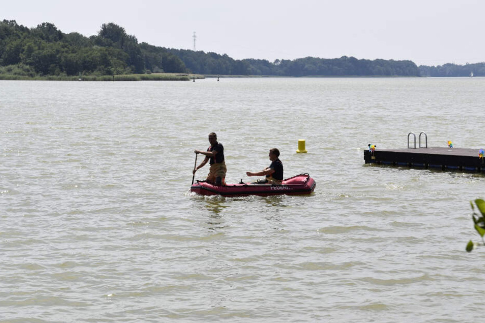 Einsatzkräfte der Feuerwehr sind mit einem Schlauchboot am Dienstag auf dem Ruppiner See unterwegs.