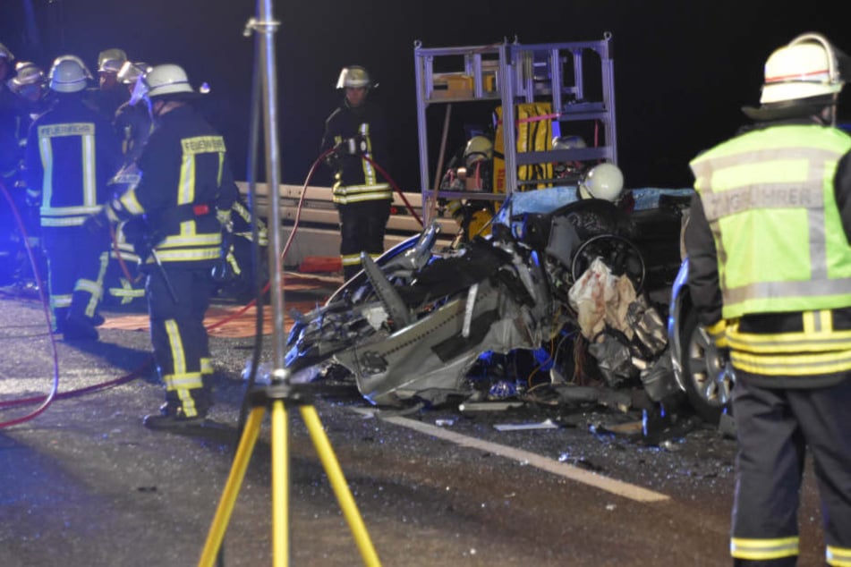 Feuerwehrleute neben dem verunfallten BMW.
