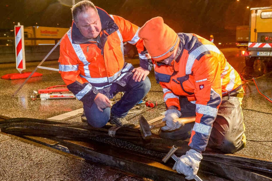 Zwei Baustellen-Mitarbeiter reparieren den Lamellen-Bruch auf der A7. (Archivbild)