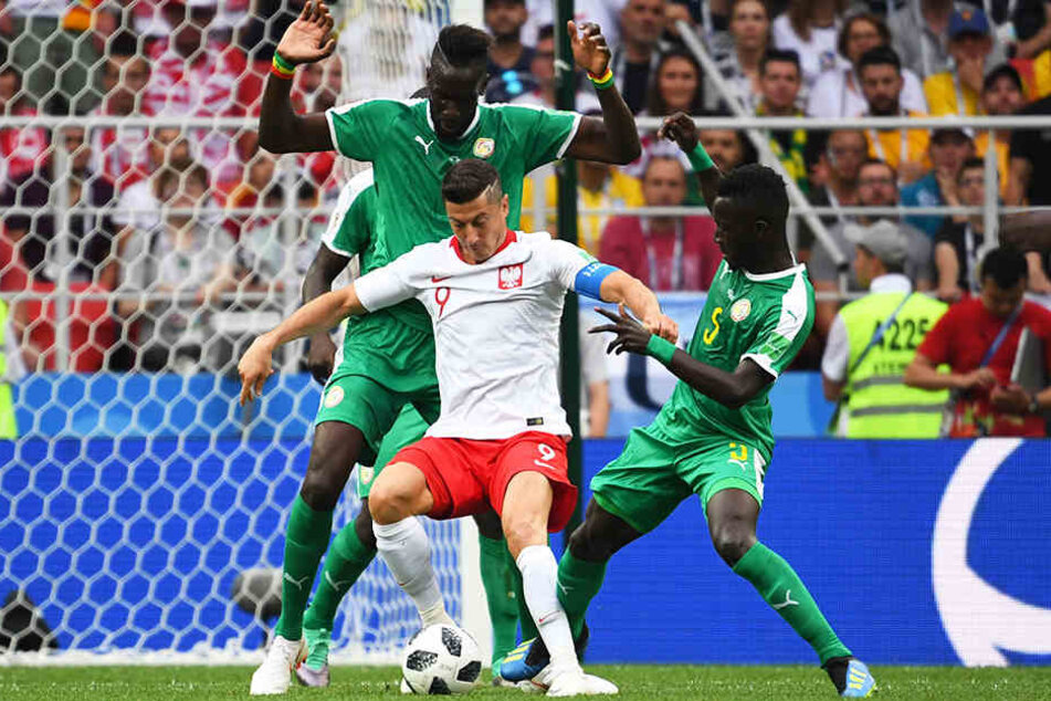 Polens Superstar Robert Lewandowski (M.) vom FC Bayern München wurde von Hannover-96-Verteidiger Salif Sane (l) und Torschütze Idrissa Gueye (r.) aus dem Senegal eng beschattet und konnte sich nur selten entfalten.