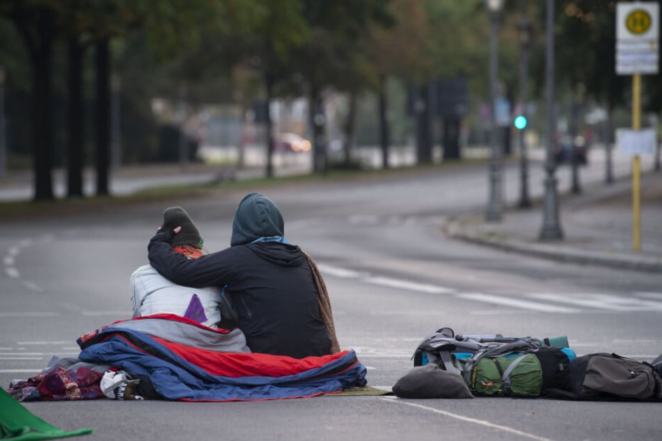 Klima-Aktivisten haben die Zufahrten zum Großen Stern blockiert. Dieses Pärchen sitzt auf der Straße, die zum Schloß Bellevue führt.