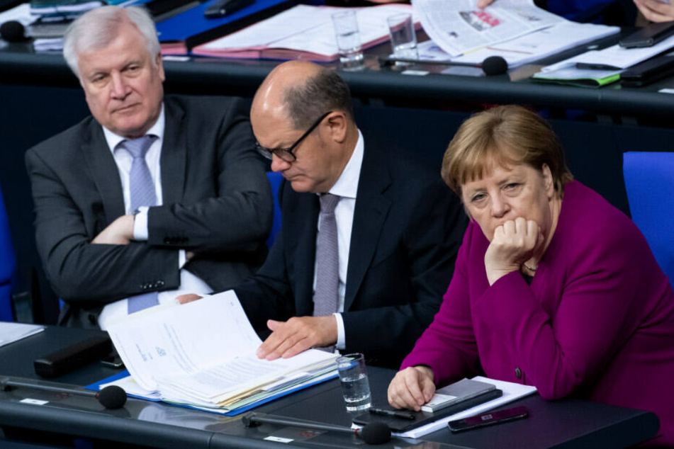 Horst Seehofer (CSU), Olaf Scholz (SPD) und Angela Merkel (CDU) sitzen im Deutschen Bundestag.
