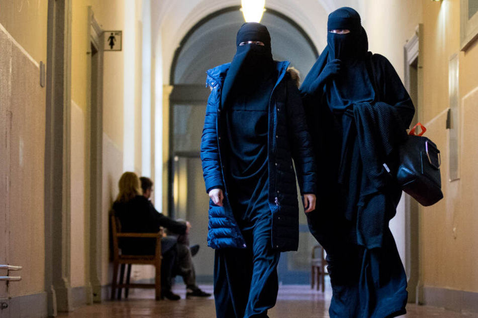 Zwei Frauen mit Nikab-Vollschleier gehen zum Beginn der Hauptverhandlung im Strafverfahren gegen sechs mutmaßliche Salafisten in den Gerichtssaal im Strafjustizgebäude in Hamburg.