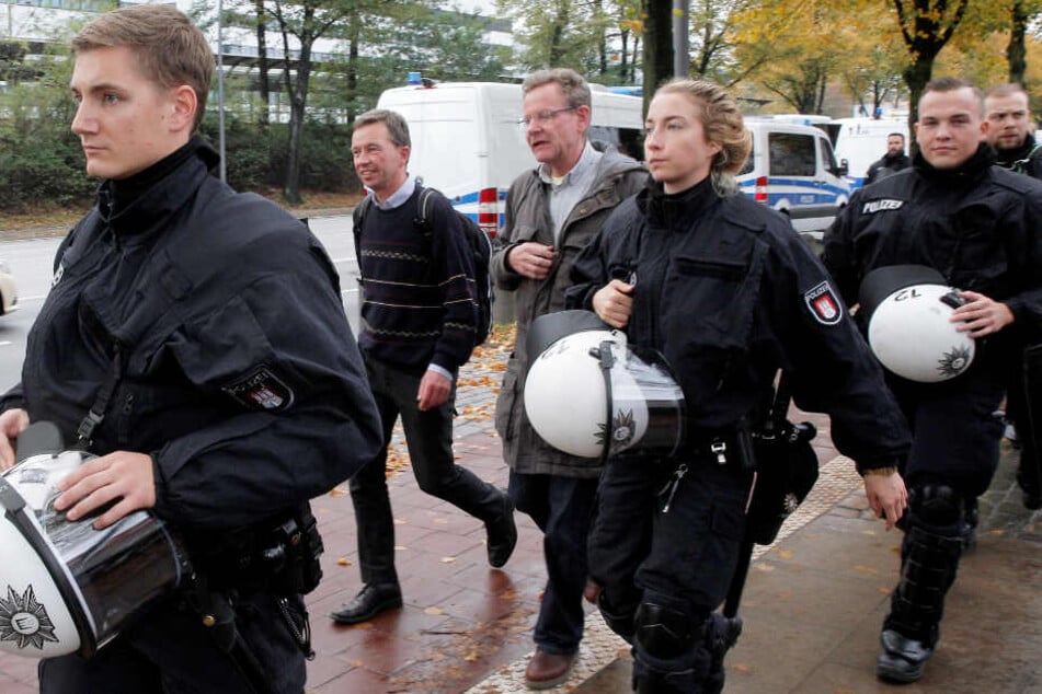 Unter Polizeischutz verlässt Bernd Lucke die Uni Hamburg.