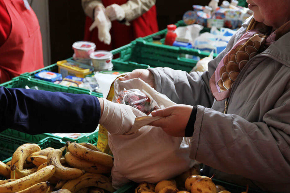 Eine Mitarbeiterin der Berliner Tafel verteilt Obst an Bedürftige.