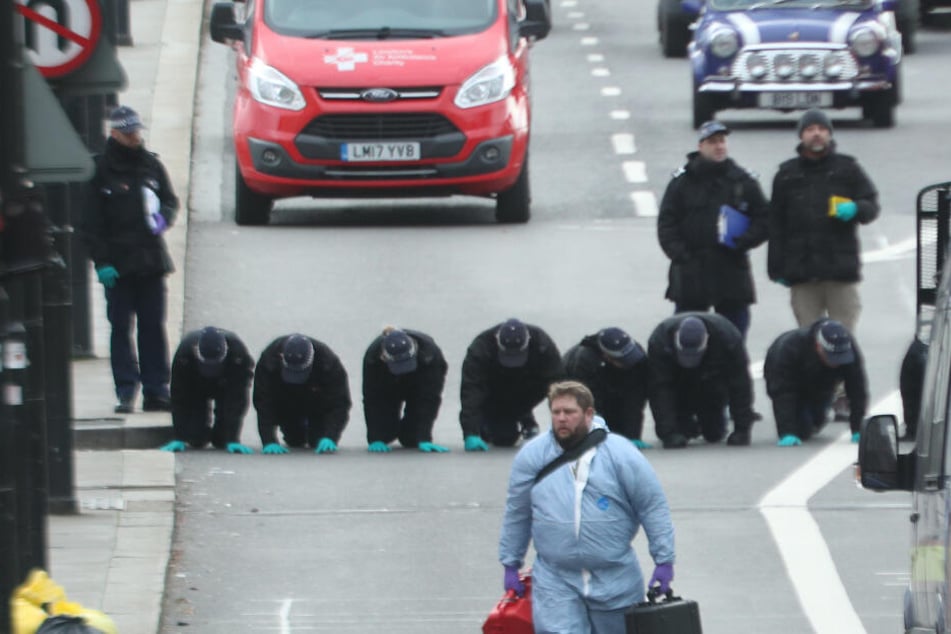 Mitarbeiter der Spurensicherung nehmen Fingerabdrücke.