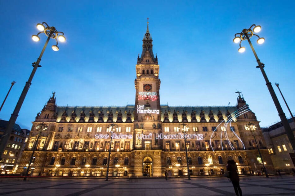 Das Rathaus Hamburg ist anlässlich des Jubiläums mit dem Lichter-Schriftzug "Von allen für alle - 100 Jahre Uni Hamburg" geschmückt.