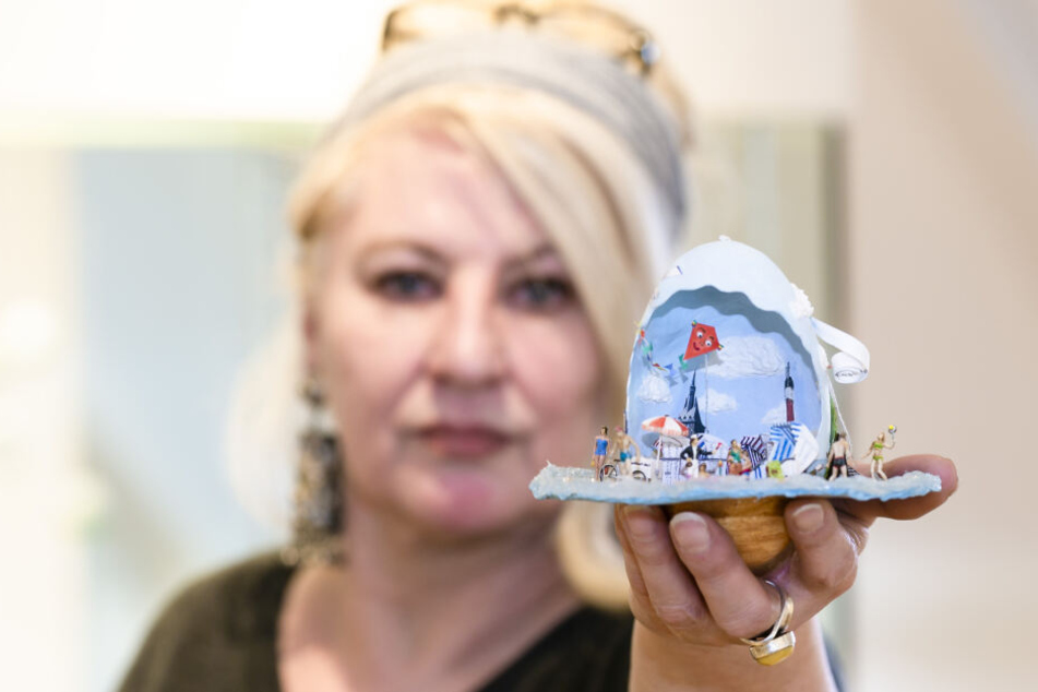 Die Künstlerin Edda Henschel präsentiert ein Exponat in der Ausstellung "Die Welt im Ei" im Ostholstein-Museum.