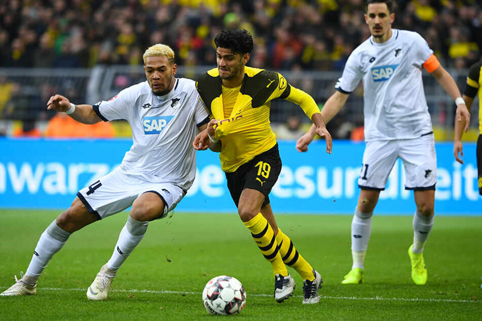 Mit Haken und Ösen: Dortmunds Mahmoud Dahoud (M.) im Duell mit TSG-Sturmkante Joelinton (l.). Hoffenheims Kapitän Benjamin Hübner beobachtet den Zweikampf gebannt.