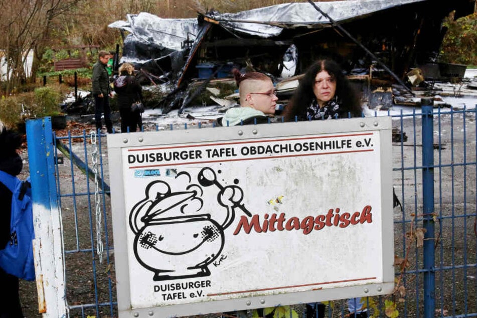 Tafel-Leiterin Petra Klein (r) und ihre Tochter Svenja Klein stehen vor der von einem Feuer zerstörten Essensausgabe der Duisburger Tafel.