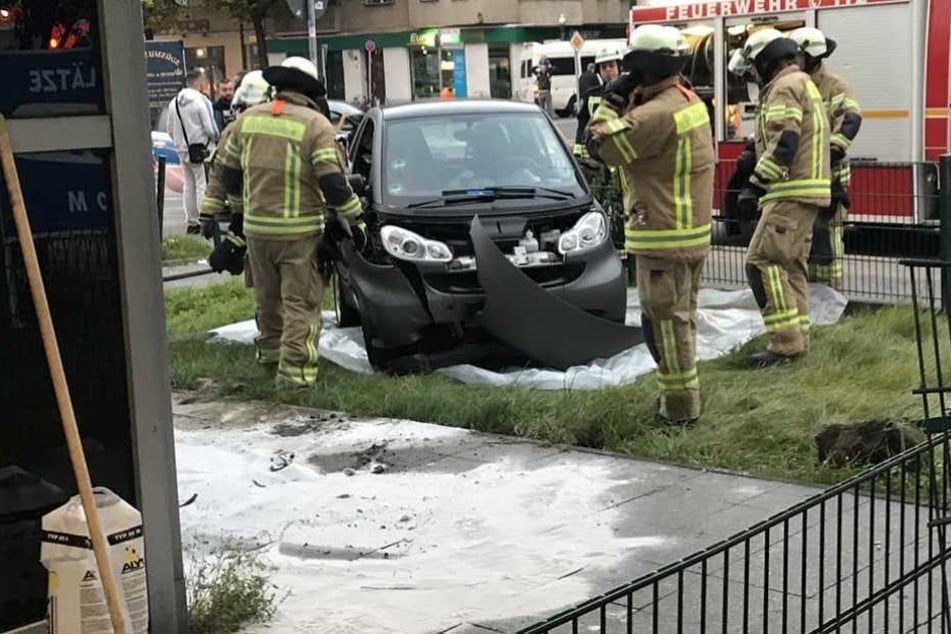 Rettungskräfte an der Unfallstelle, an der der Smart den Zaun durchbrach.