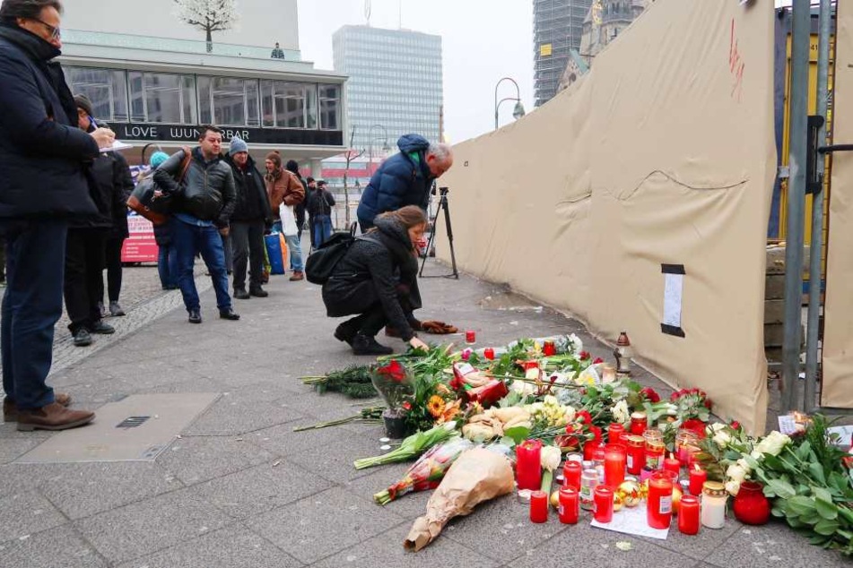 Menschen legen Blumen am Breitscheidplatz in Berlin ab.