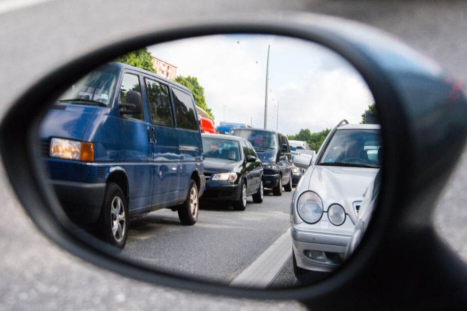 Autos stehen in Hamburg auf der A7 bei Stellingen im Stau und sind dabei im Rückspiegel zu sehen.