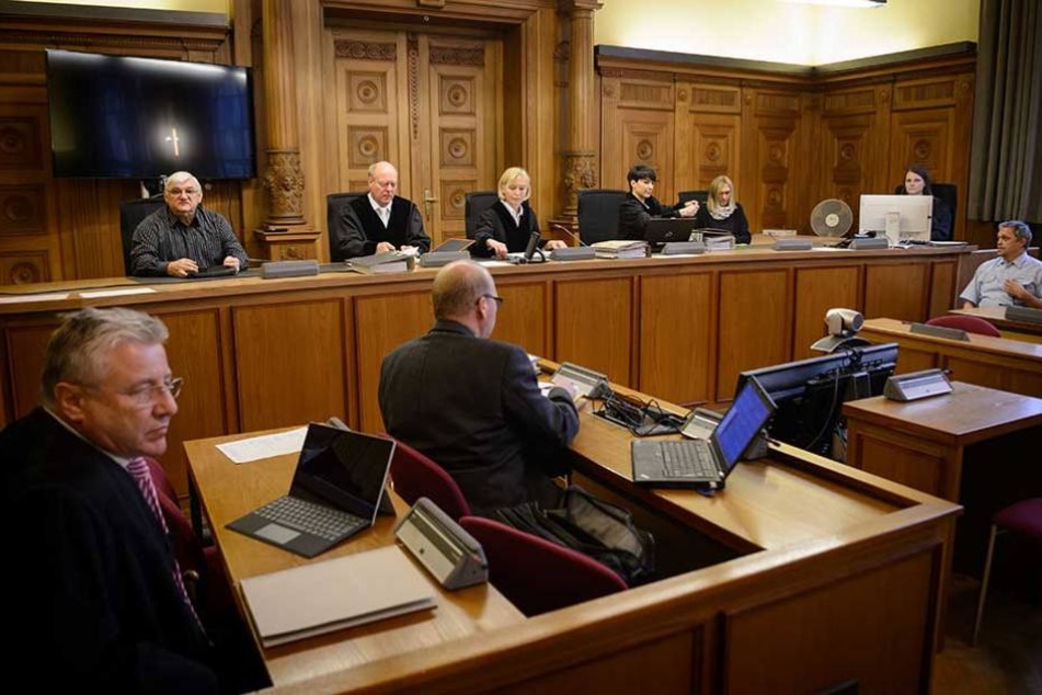 Bernd C. Gerritzen (l), Rechtsanwalt der Geschädigten, ein Gutachter (M) und die Richter sitzen vor Prozessbeginn auf ihren Plätzen.
