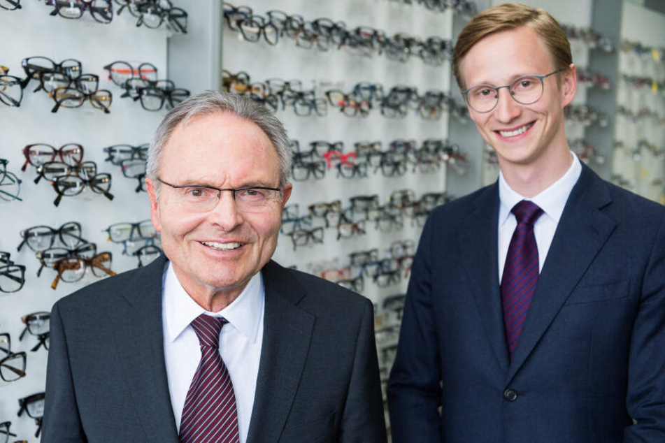 Der Vorstandsvorsitzende der Fielmann AG, Günther Fielmann (links), und sein Sohn Marc Fielmann lächeln in die Kamera.